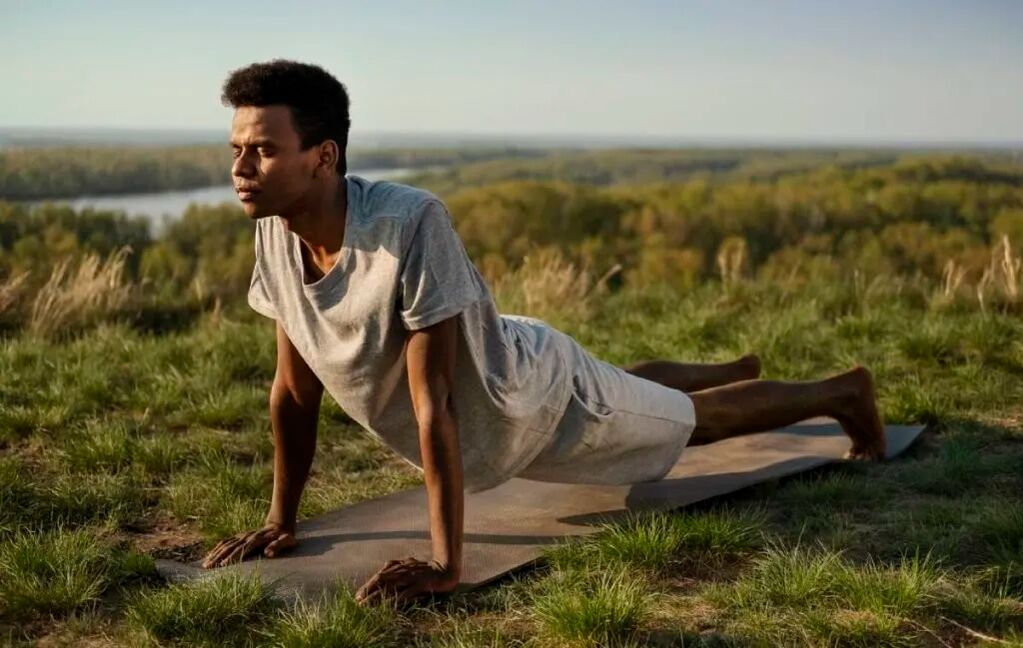 Homme faisant du yoga dans la nature